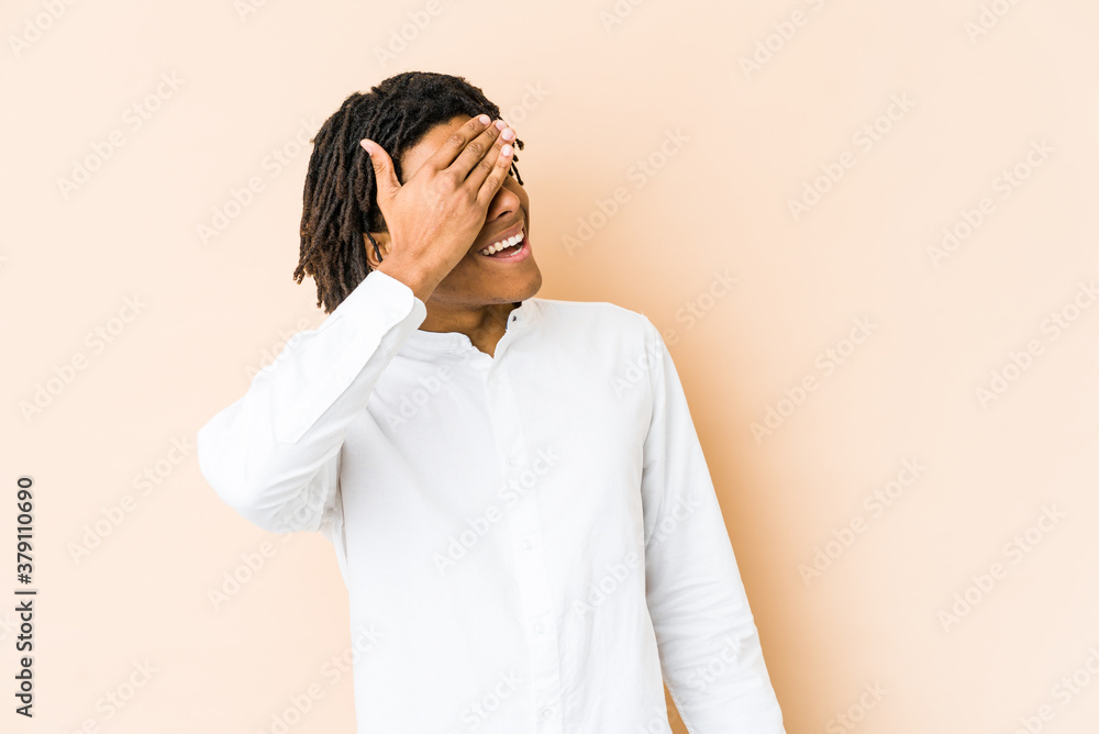 Young african american rasta man covers eyes with hands, smiles broadly waiting for a surprise. Young african american rasta man covers eyes with hands, smiles broadly waiting for a surprise.