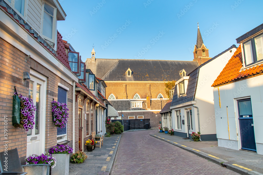 Ulica w Egmond aan Zee z widokiem na Kościół. Kurort nadmorski położony nad Morzem Północnym, Holandia Północna.