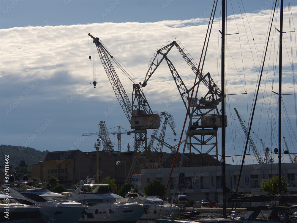 Fototapeta premium Port cranes for unloading and loading ship transport, Croatia port in the city of Trogir