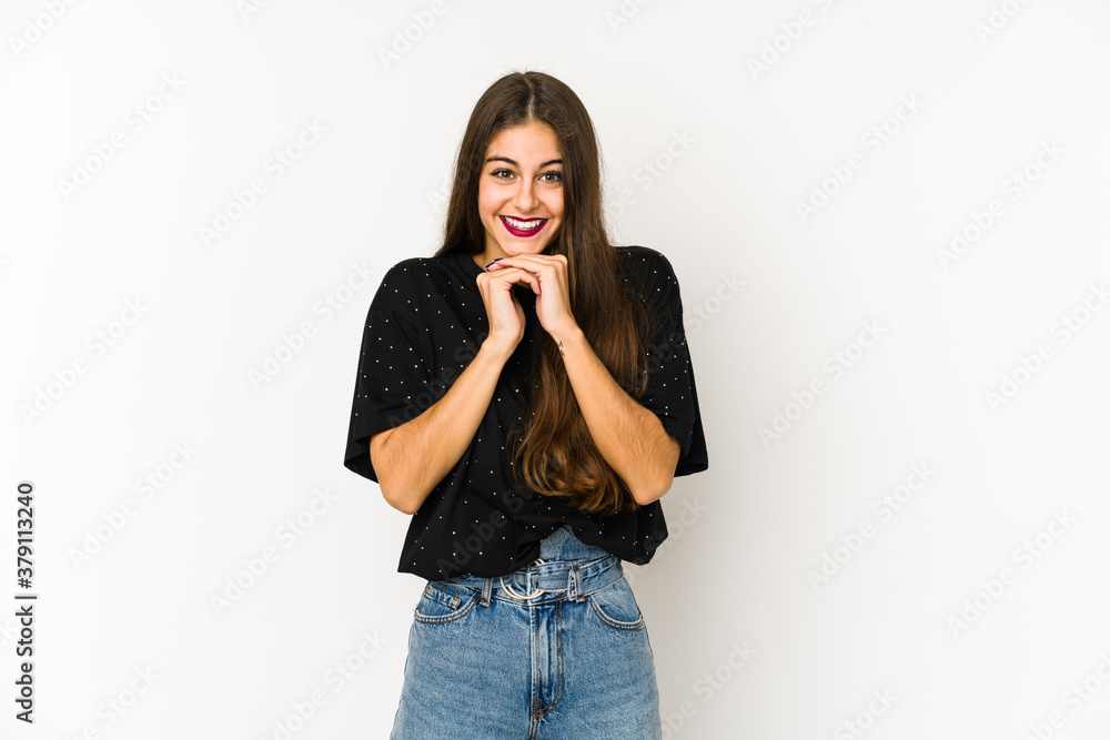 Young caucasian woman isolated on white background keeps hands under chin, is looking happily aside. Young caucasian woman isolated on white background keeps hands under chin, is looking happily aside.