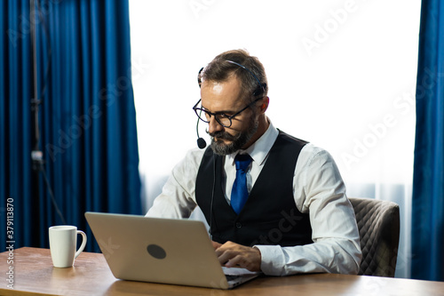 Tele marketing sale support operator with hands-free headset working in the office. Customer service. Online learning and video conference concept