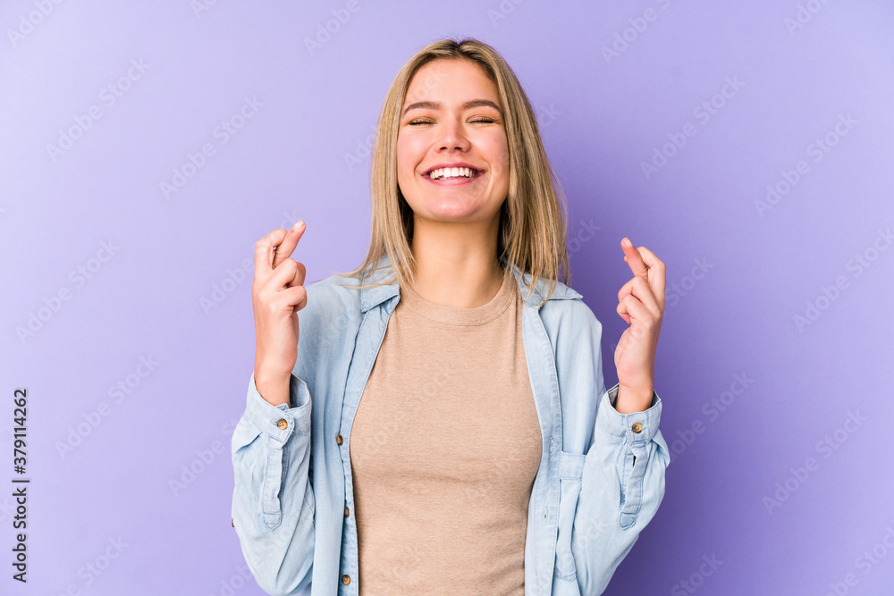 Young blonde caucasian woman isolated crossing fingers for having luck Young blonde caucasian woman isolated crossing fingers for having luck