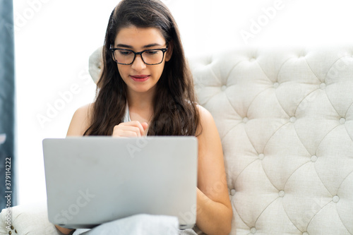 Young caucasian woman happy cheerful working and checking mailbox on laptop computer sitting on sofa at home.