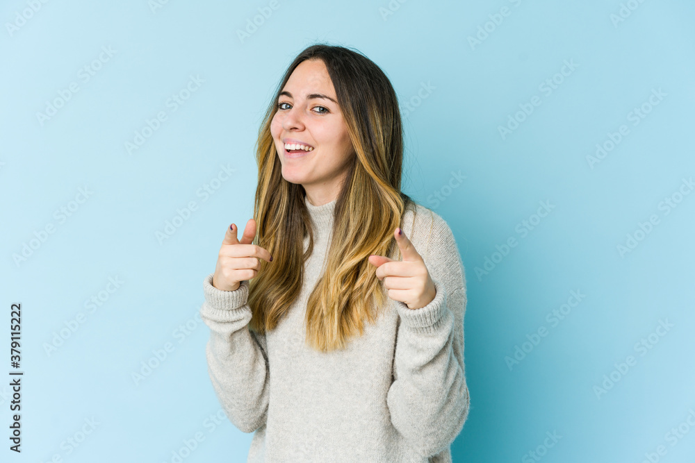 Fototapeta premium Young caucasian woman isolated on blue background pointing to front with fingers.