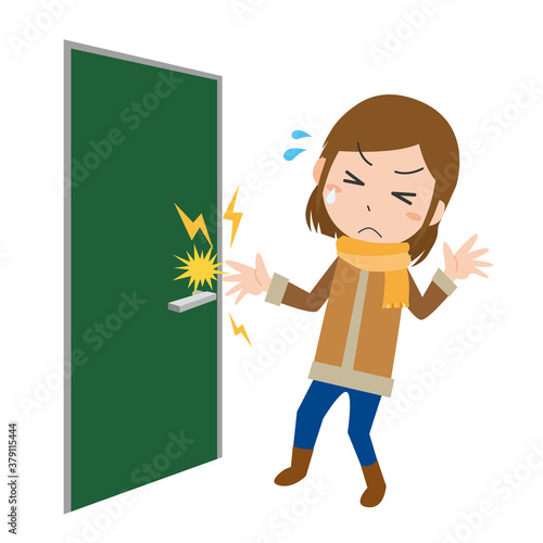 ドアノブを握ろうとして静電気に痛がる女性