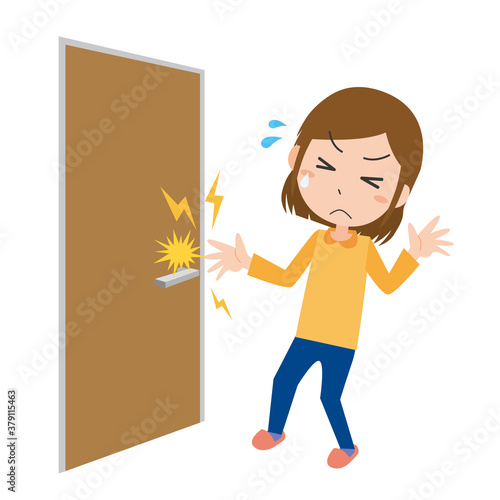 ドアノブを握ろうとして静電気に痛がる女性