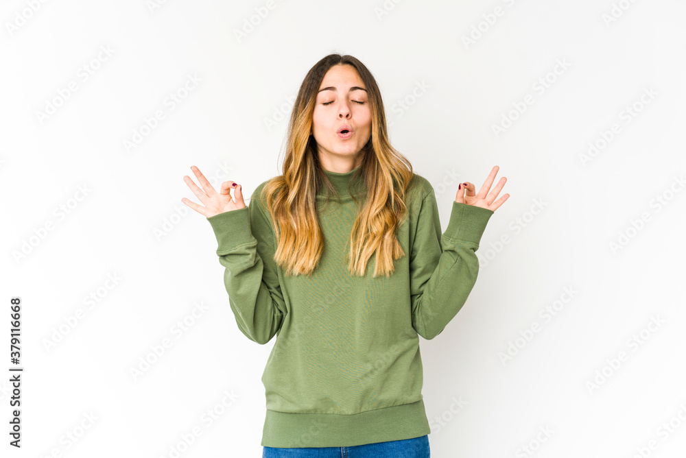 Young caucasian woman isolated on white background relaxes after hard working day, she is performing yoga. Young caucasian woman isolated on white background relaxes after hard working day, she is performing yoga.