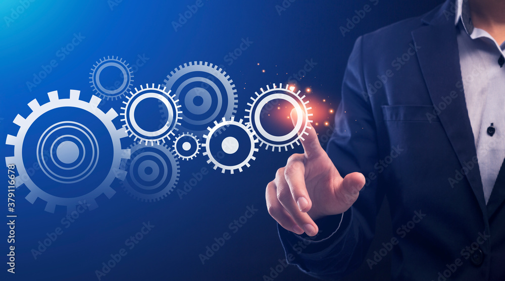 Businessman Pushing Key Starting Cogwheels Mechanism, Blue Background, Conceptual Collage Businessman Pushing Key Starting Cogwheels Mechanism, Blue Background, Conceptual Collage