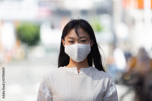 マスク姿の若い女性。 COVID-19 パンデミックコロナウイルス。病気の拡大を防ぐマスクを着けている若い女性のポートレイト。