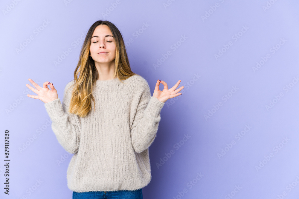 Young caucasian woman isolated on purple background relaxes after hard working day, she is performing yoga. Young caucasian woman isolated on purple background relaxes after hard working day, she is performing yoga.