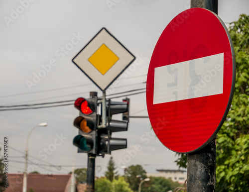 No entry traffic sign and stop lights in the background.