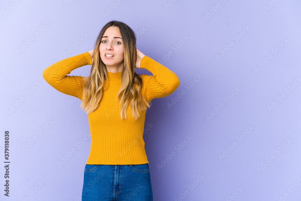 Young caucasian woman isolated on purple background touching back of head, thinking and making a choice. Young caucasian woman isolated on purple background touching back of head, thinking and making a choice.