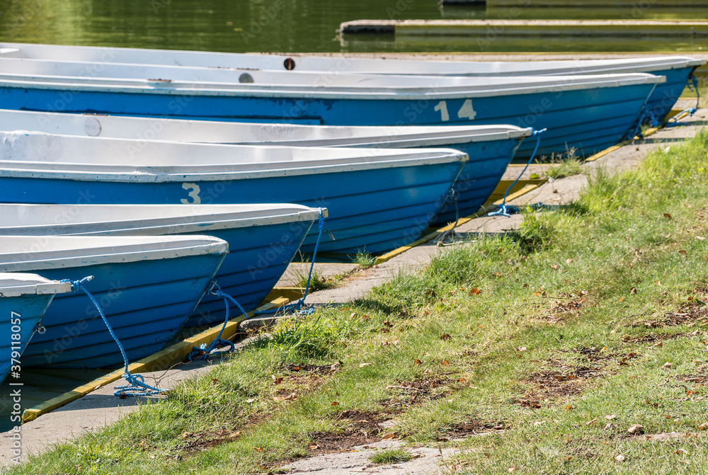 Many blue boats with numbers aligned at the pier in Alexandru Ioan Cuza Park, Bucharest Many blue boats with numbers aligned at the pier in Alexandru Ioan Cuza Park, Bucharest