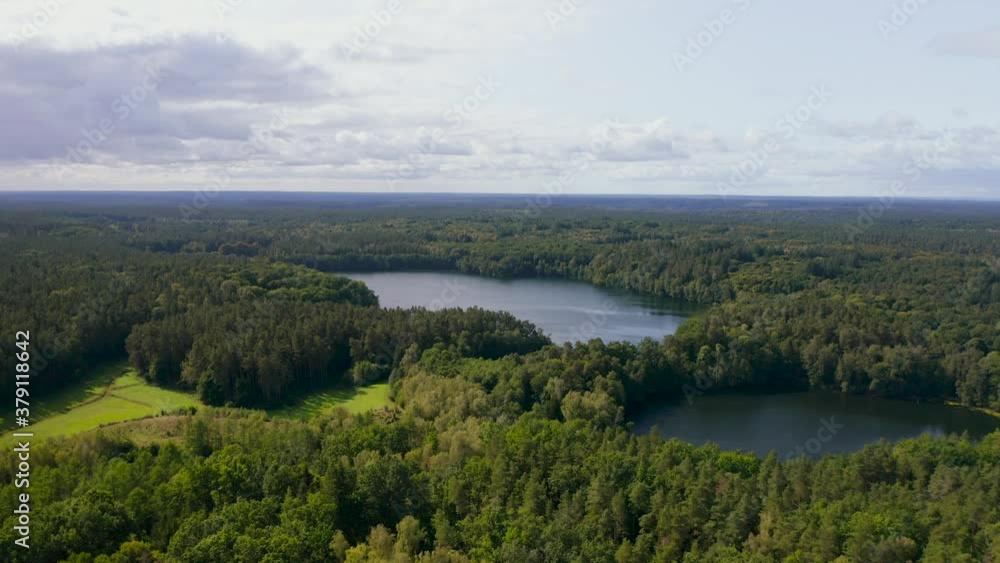 Aerial rising view overlooking vast back country woodland wilderness and lake Aerial rising view overlooking vast back country woodland wilderness and lake