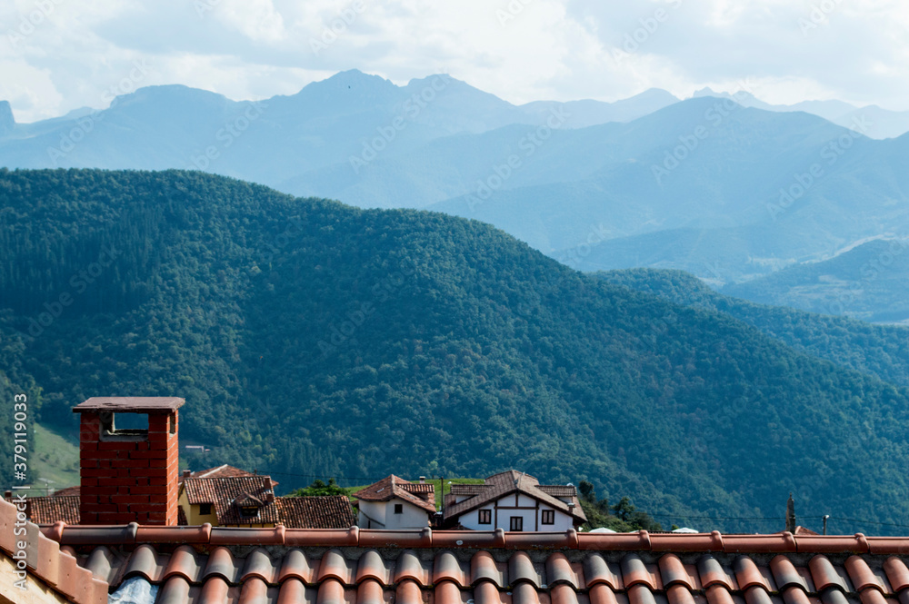 Vistas y tejado de un pueblo, rodeado de montañas y entorno rural.