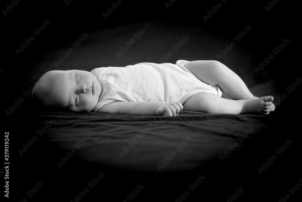 Obraz premium Newborn baby sleeps on a black background.