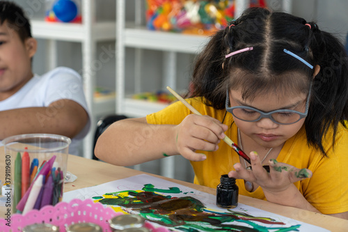 Obraz na plátne Autistic, Autism or Down Syndrome children girl are painting their own hands