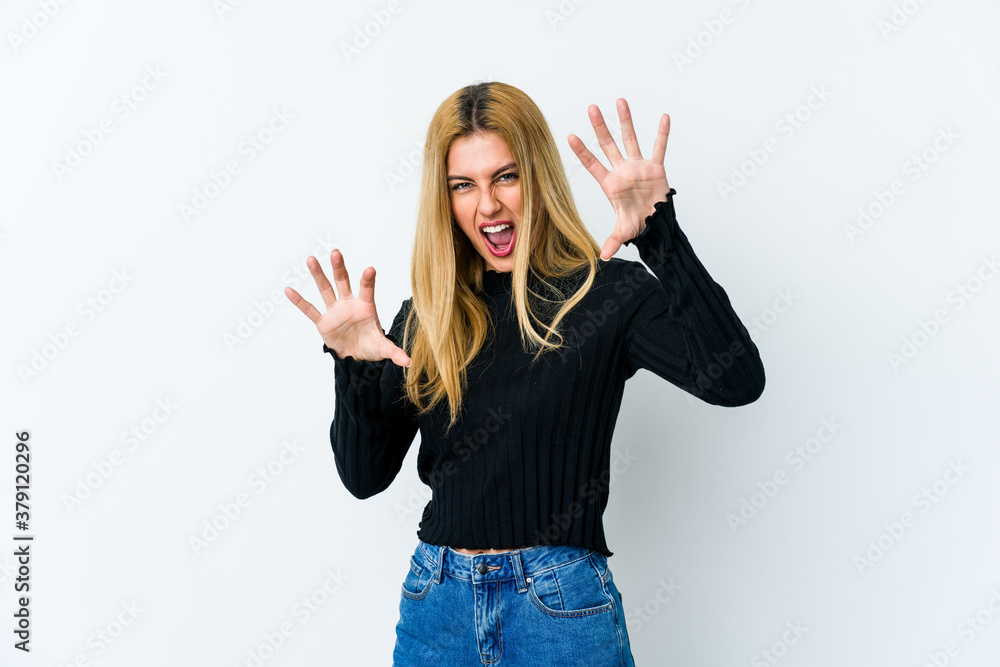 Young blonde woman isolated on white background showing claws imitating a cat, aggressive gesture. Young blonde woman isolated on white background showing claws imitating a cat, aggressive gesture.