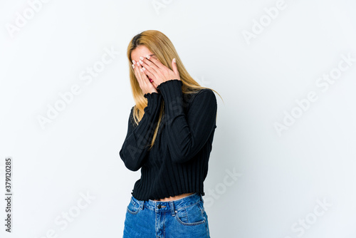 Young blonde woman isolated on white background afraid covering eyes with hands.