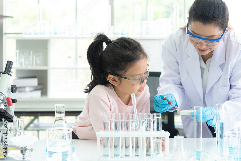 Asian children analyzing study evaluating microscope with scientist. Health care researchers doing some research Asian children analyzing study evaluating microscope with scientist. Health care researchers doing some research