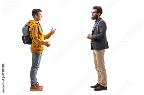 Full length profile shot of a male teenager talking to a beared man