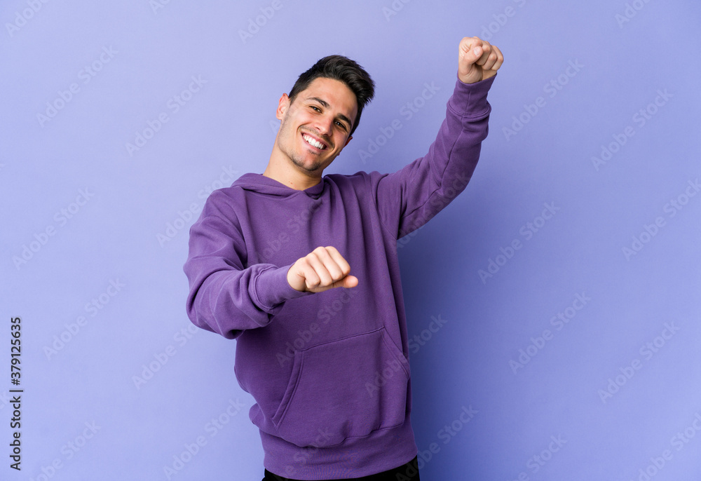 Fototapeta premium Young caucasian man isolated on purple background dancing and having fun.