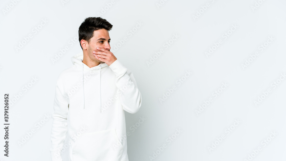 Young caucasian man isolated on white background thoughtful looking to a copy space covering mouth with hand. Young caucasian man isolated on white background thoughtful looking to a copy space covering mouth with hand.