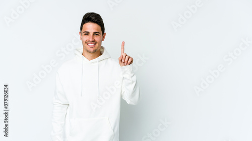 Young caucasian man isolated on white background showing number one with finger.