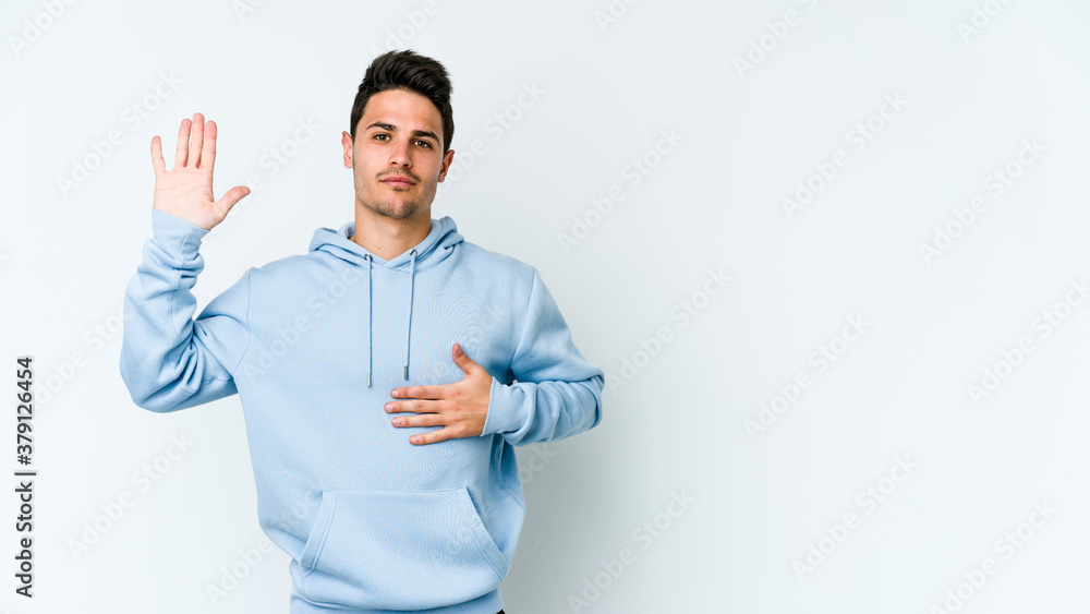 Young caucasian man isolated on white background taking an oath, putting hand on chest. Young caucasian man isolated on white background taking an oath, putting hand on chest.