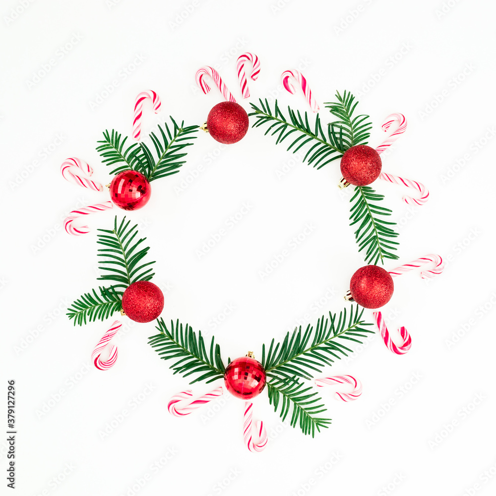 Merry Christmas composition of branches and red decoration with candy cane on white. Flat lay, top view