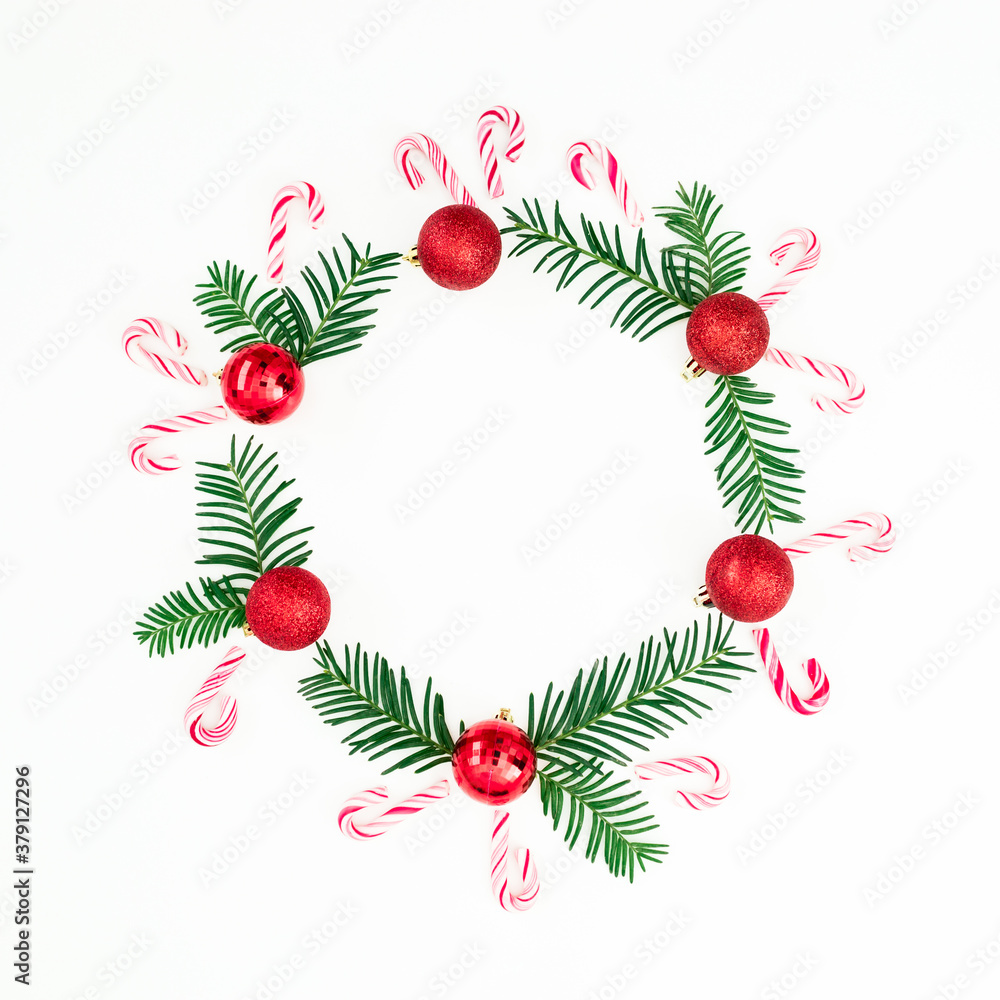 Merry Christmas composition of branches and red decoration with candy cane on white. Flat lay, top view Merry Christmas composition of branches and red decoration with candy cane on white. Flat lay, top view