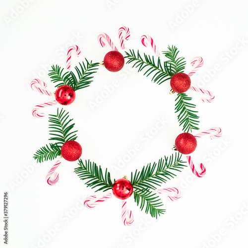 Merry Christmas composition of branches and red decoration with candy cane on white. Flat lay, top view