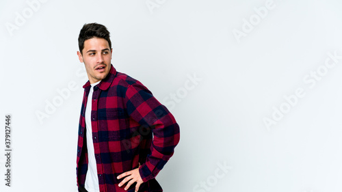 Young caucasian man isolated on white background looks aside smiling, cheerful and pleasant.
