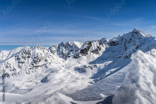 View from Kasprowy Wierch at Swinica mountain peak at winter. Amazing mountain range with snow capped mountain peaks in Tatra Mountains  Poland