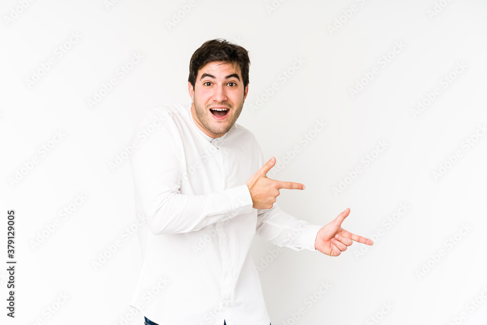 Young man isolated on white background excited pointing with forefingers away. Young man isolated on white background excited pointing with forefingers away.