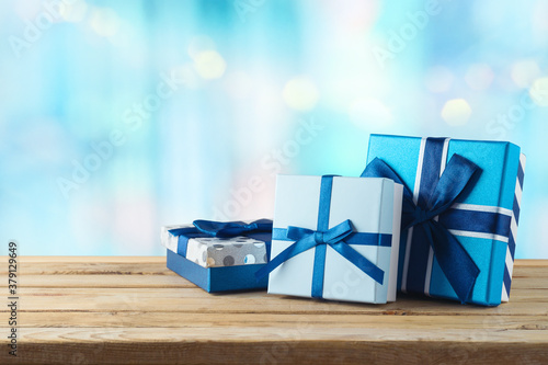 Blue gift boxes on wooden table. Christmas or Hanukkah celebration concept. photo