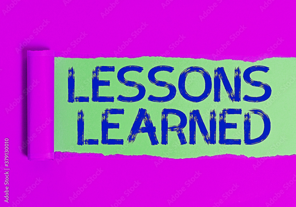 Fototapeta premium Conceptual hand writing showing Lessons Learned. Concept meaning the knowledge or understanding gained by experience Rolled ripped torn cardboard above a wooden classic table