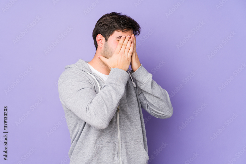 Young man isolated on purple background afraid covering eyes with hands. Young man isolated on purple background afraid covering eyes with hands.