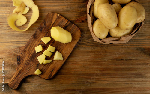 Raw Chopped Potato on Wooden Cutting Board Background