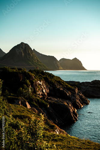 Sharp rocks with small lighthouse. Beautiful landscape. Fjord, polar day, arctic ocean. Northern Norway. Sunset. 