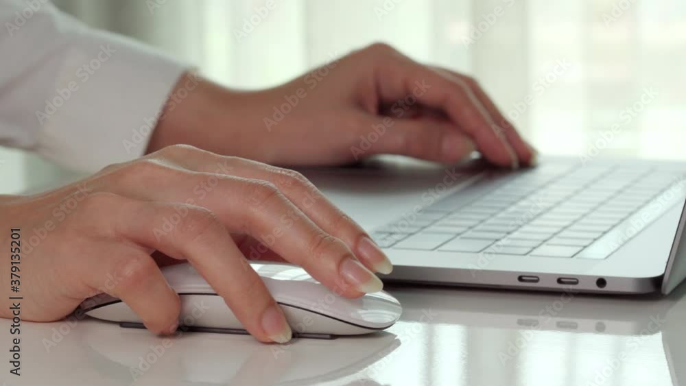 close-up female hand of business woman using mouse to working with a laptop computer close-up female hand of business woman using mouse to working with a laptop computer