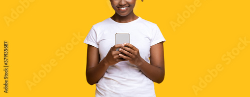 Unrecognizable black woman with modern smartphone, cropped