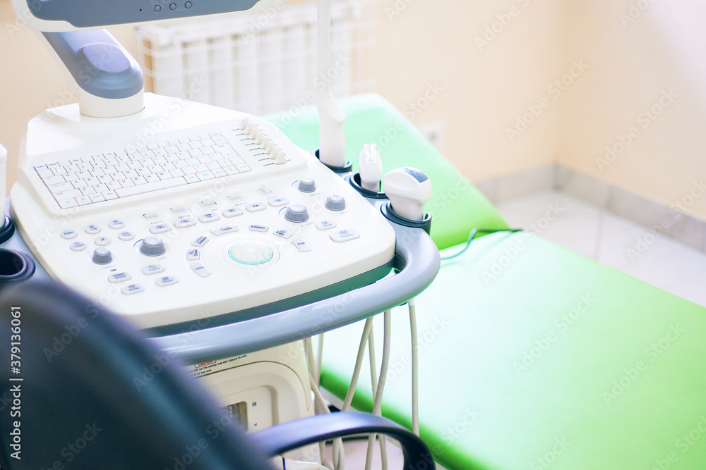 Hospital equipment. Close-up of the ultrasound machine in the clinic. Ultrasound examinations for pregnant women and people with diseases of internal organs. Modern medicine. Couch for the patient.