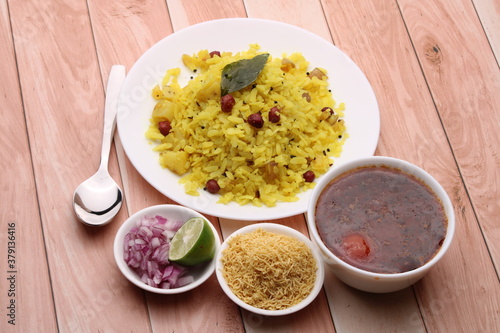 Aloo/Kanda Poha or Tarri Pohe with spicy chana masala/curry. Served in ceramic plate. photo