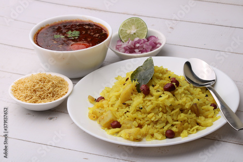 Aloo/Kanda Poha or Tarri Pohe with spicy chana masala/curry. Served in ceramic plate. photo