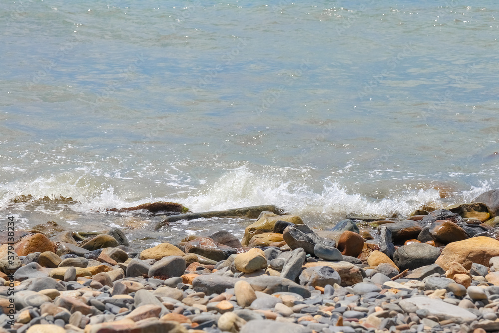 pebbles and stones on the beach. waves and splashes on the shore pebbles and stones on the beach. waves and splashes on the shore