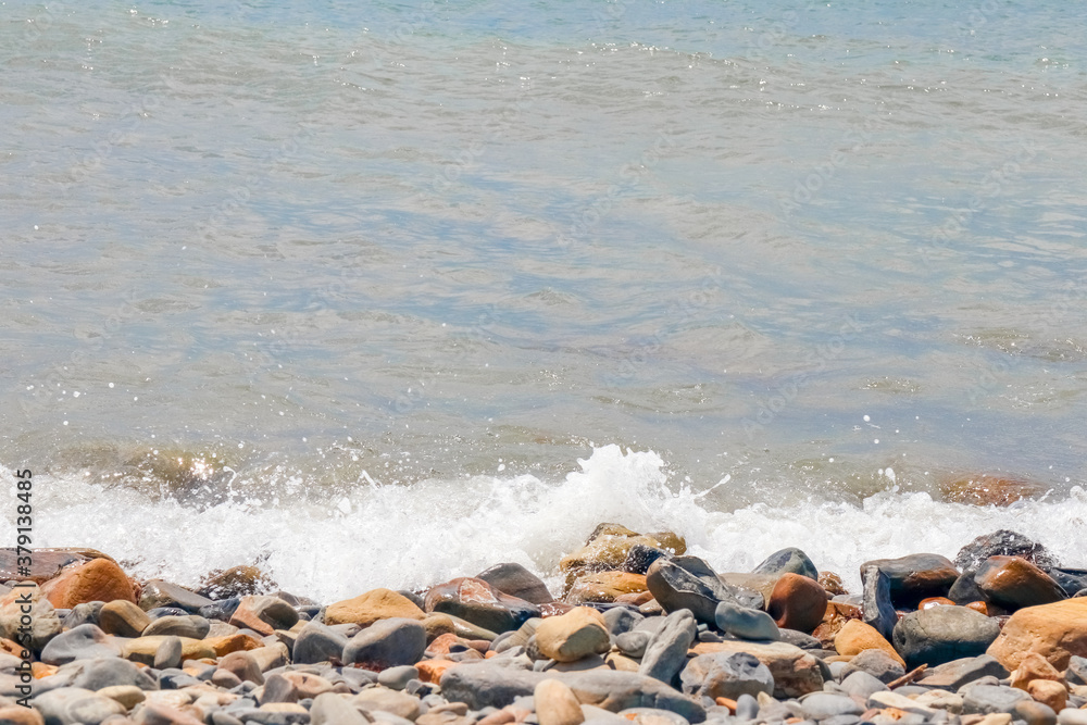 pebbles and stones on the beach. waves and splashes on the shore pebbles and stones on the beach. waves and splashes on the shore
