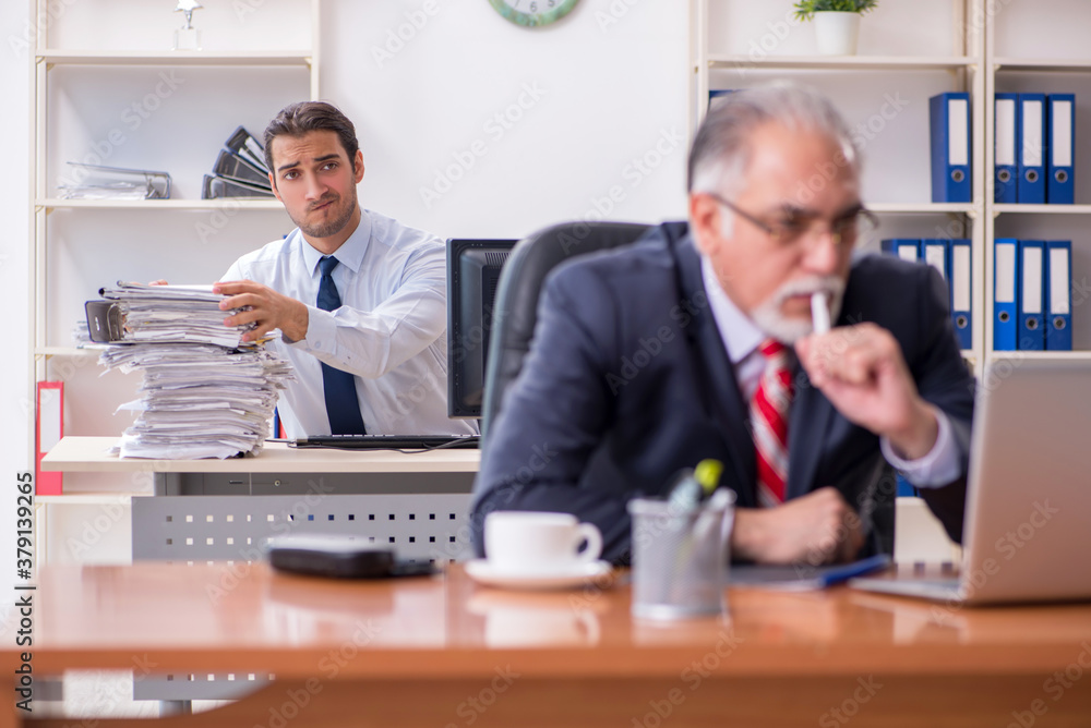Old boss and young male employee in the office Old boss and young male employee in the office