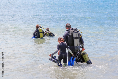 divers enter the water on the beach