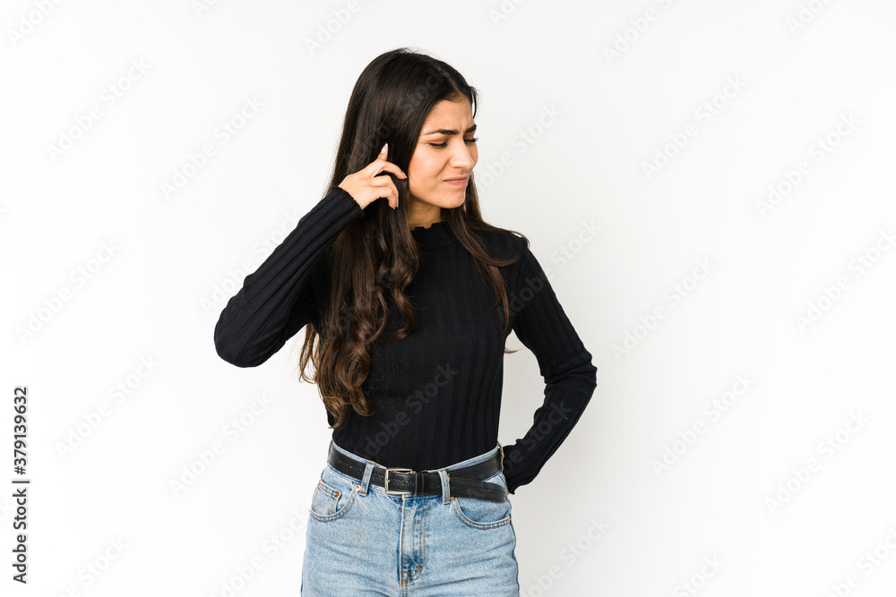 Young indian woman isolated on purple background covering ears with fingers, stressed and desperate by a loudly ambient. Young indian woman isolated on purple background covering ears with fingers, stressed and desperate by a loudly ambient.